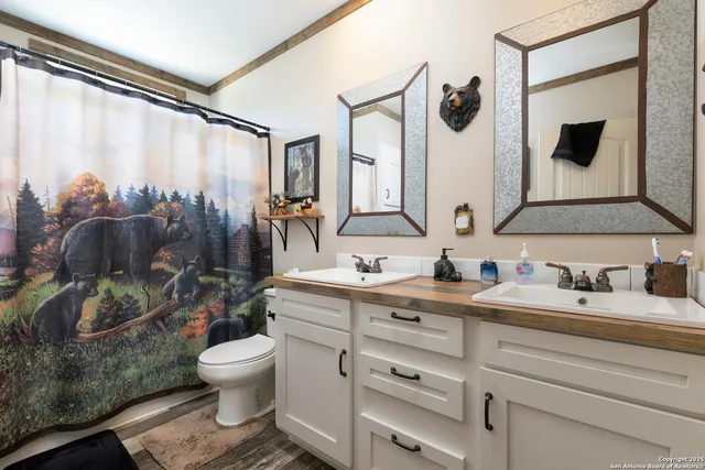 a bathroom with a granite countertop sink mirror vanity and toilet