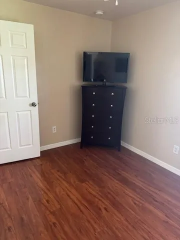 a view of an empty room with wooden floor