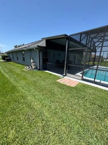 a backyard of a house with table and chairs