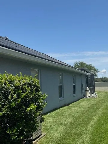a backyard of a house with table and chairs with wooden fence