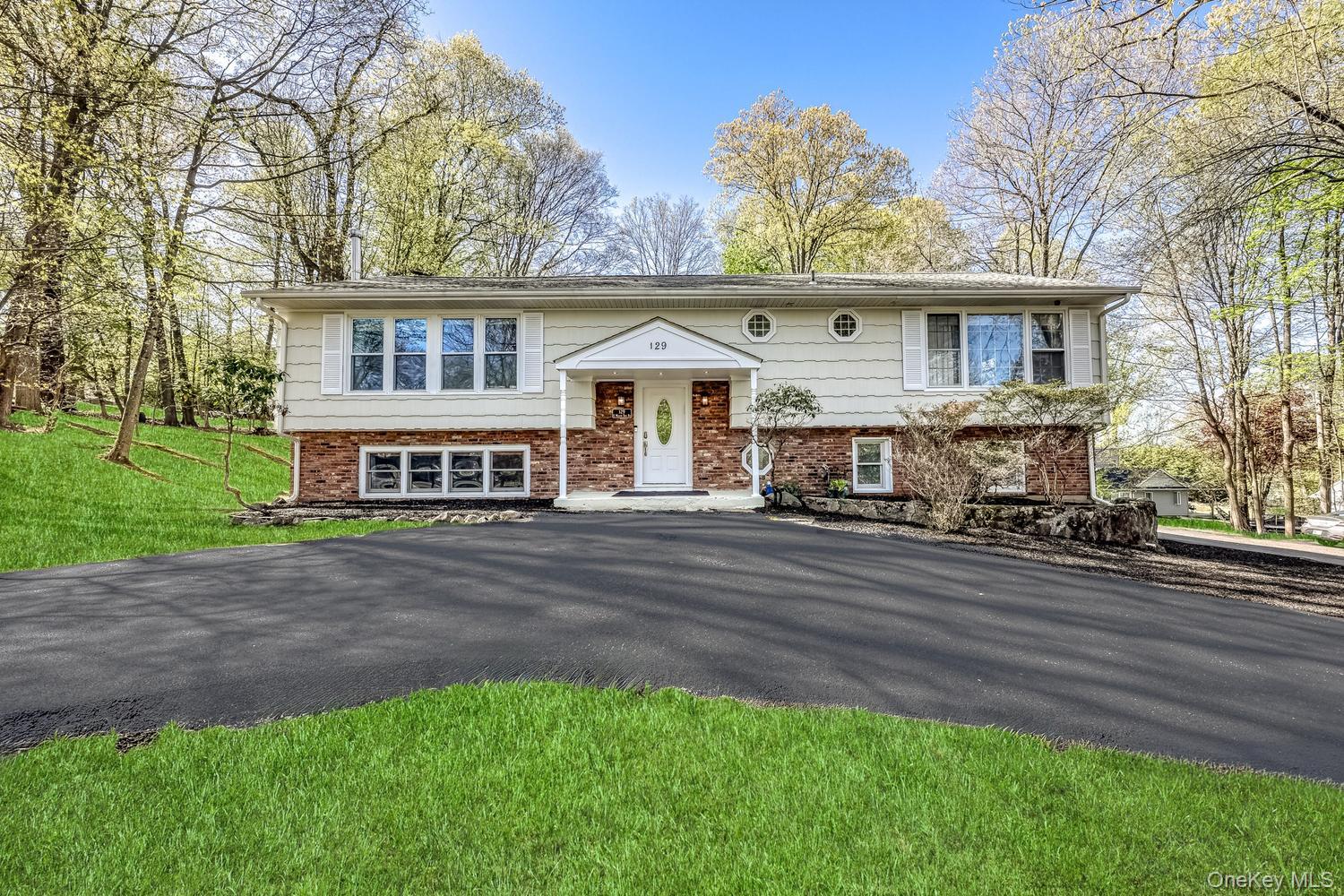 129 East Willow Tree Road Spring Valley, NY 10977 - Photo 1 of 30 a front view of a house with a yard table and chairs