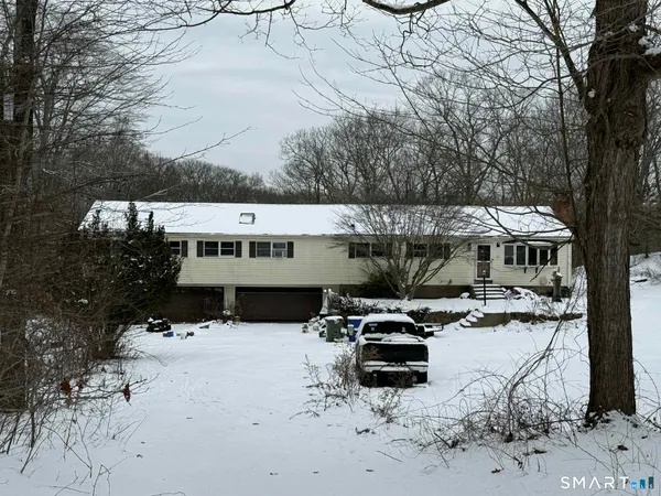 a view of a house with a yard patio and car parked