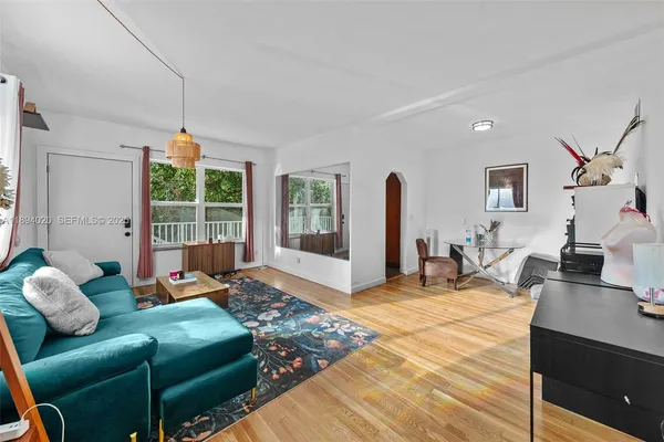a living room with furniture a flat screen tv and a large window