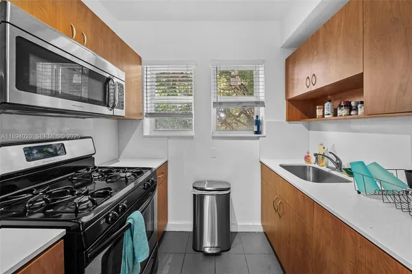 a kitchen with stainless steel appliances a sink stove and cabinets