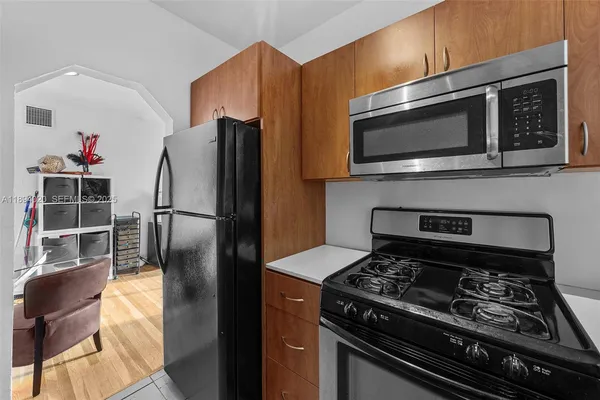 a kitchen with stainless steel appliances kitchen island granite countertop a stove microwave and refrigerator