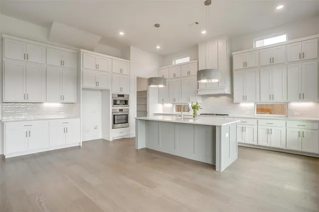 a kitchen with white cabinets and refrigerator
