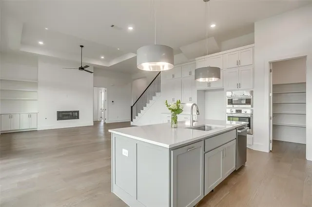 a kitchen with kitchen island a sink stainless steel appliances and cabinets
