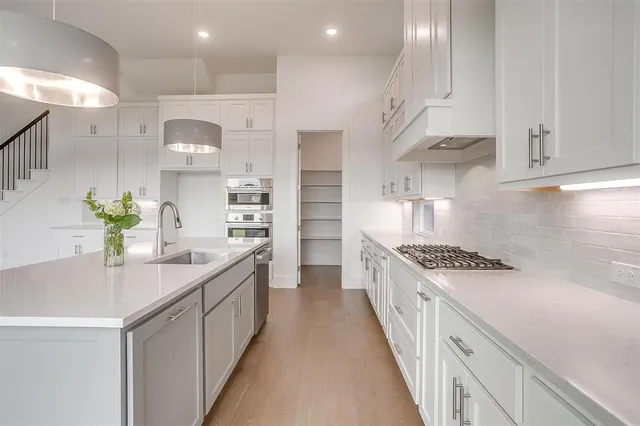 a kitchen with kitchen island white cabinets and appliances
