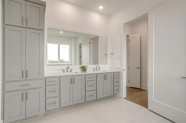 a spacious bathroom with a double vanity sink a mirror and a bathtub
