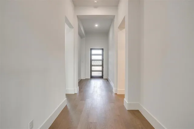 a view of a hallway with wooden floor and windows