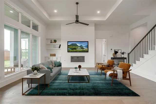 a living room with furniture a rug potted plant and a large window