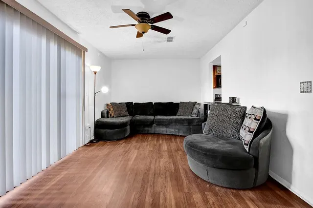 a living room with furniture and a wooden floor