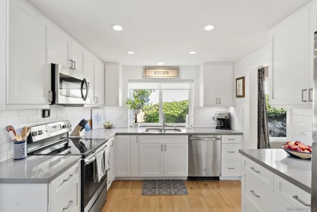 a kitchen with a sink stove top oven and refrigerator