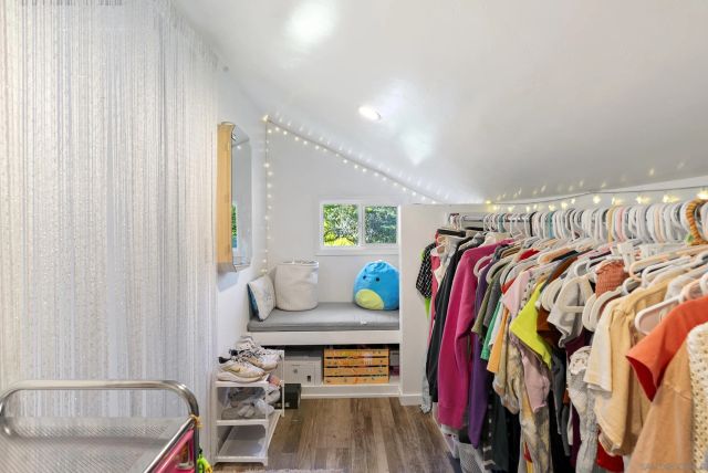 a view of walk in closet with clothes and shoes
