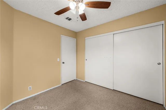 an empty room with a ceiling fan and a window