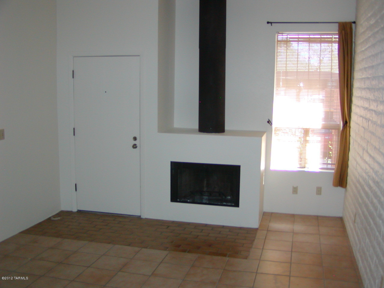 4311 East Blanton Road Tucson, AZ 85712 - Photo 2 of 8 a view of an empty room with window and fireplace