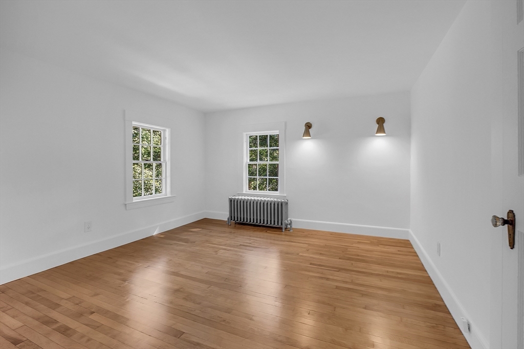 681 Barretts Mill Road Concord, MA 01742 - Photo 16 of 27 an empty room with wooden floor and windows