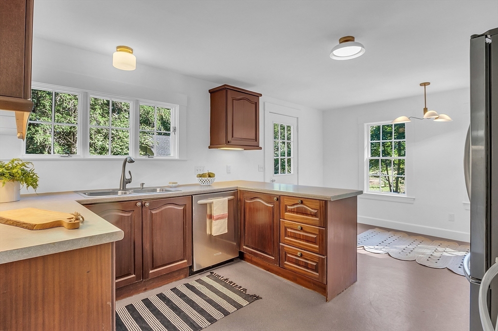 681 Barretts Mill Road Concord, MA 01742 - Photo 8 of 27 a kitchen with stainless steel appliances granite countertop a sink stove and cabinets