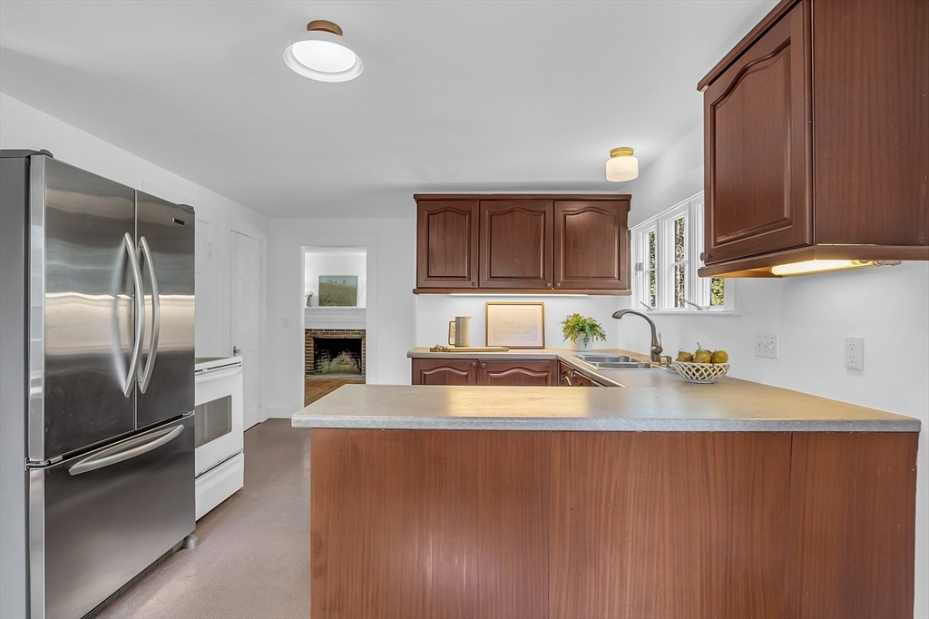 681 Barretts Mill Road Concord, MA 01742 - Photo 9 of 27 a kitchen with stainless steel appliances granite countertop a refrigerator a sink and a stove