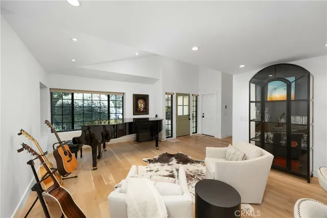 a kitchen with stainless steel appliances kitchen island granite countertop a stove a sink a refrigerator and white cabinets with wooden floor