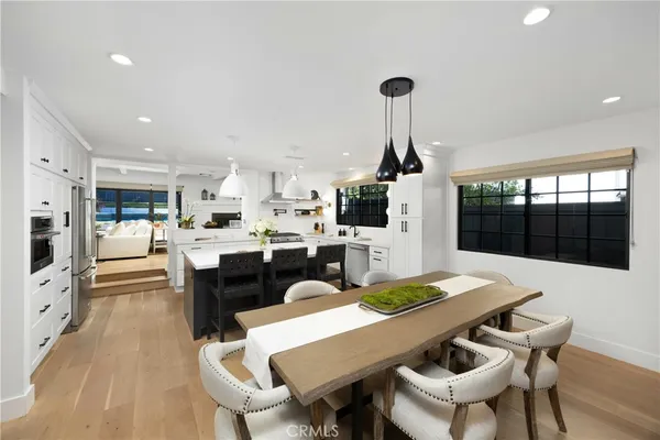 a living room with furniture large windows and wooden floor