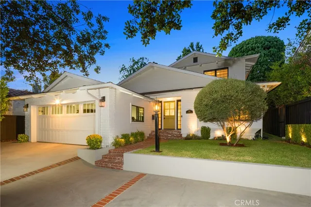a view of a house with a backyard and a tree