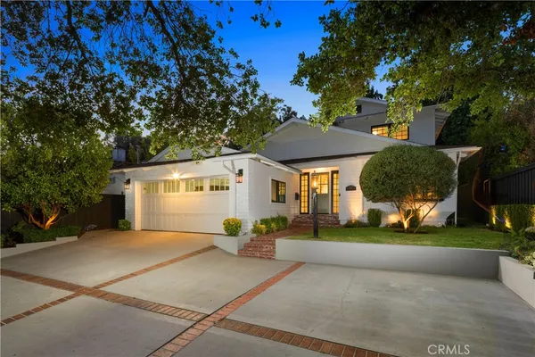 a front view of a house with a yard and trees