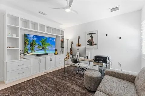 a living room with furniture a air conditioner and a flat screen tv