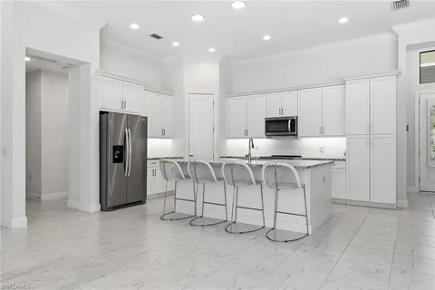 a view of kitchen with refrigerator and microwave