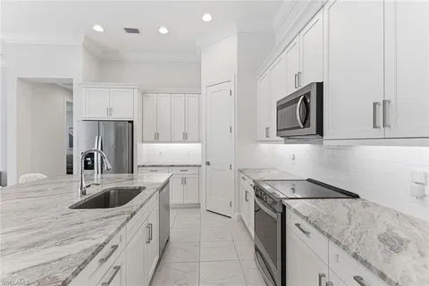 a kitchen that has a sink a stove and cabinets