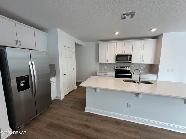 a kitchen with a refrigerator a microwave a sink and cabinets