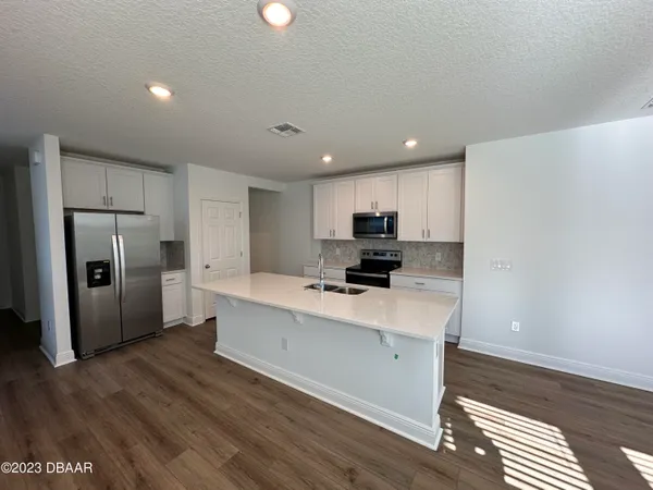 a kitchen with refrigerator cabinets and wooden floor