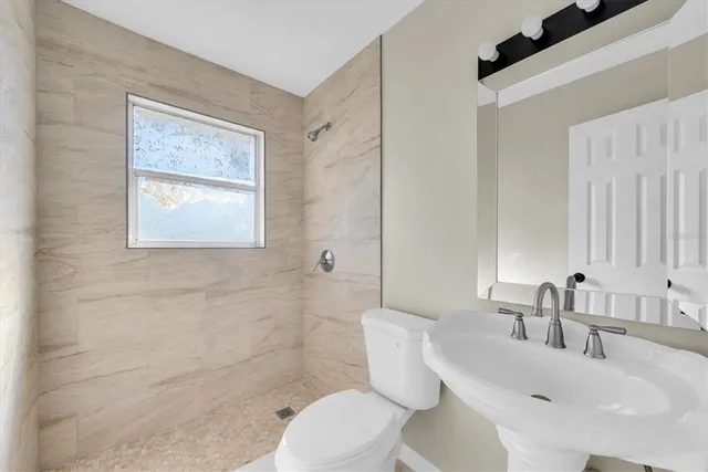 a bathroom with a toilet a sink and a mirror