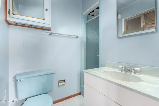 a bathroom with a sink and mirror with toilet