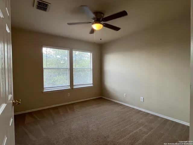 an empty room with window and fan