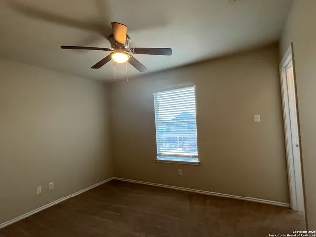 an empty room with a window and a fan