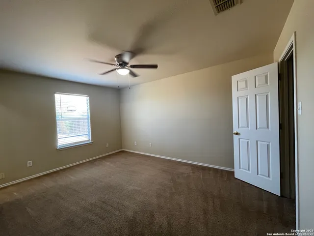 an empty room with windows and fan