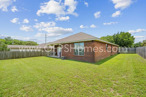 a view of an house with backyard space and balcony