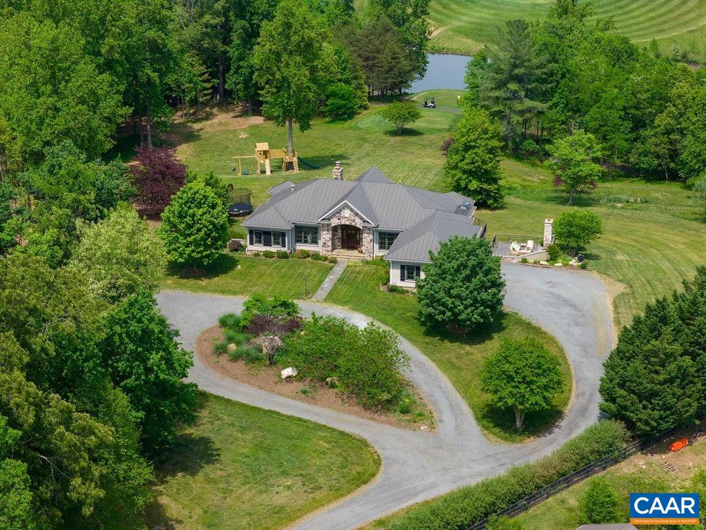 an aerial view of residential house with outdoor space and trees all around