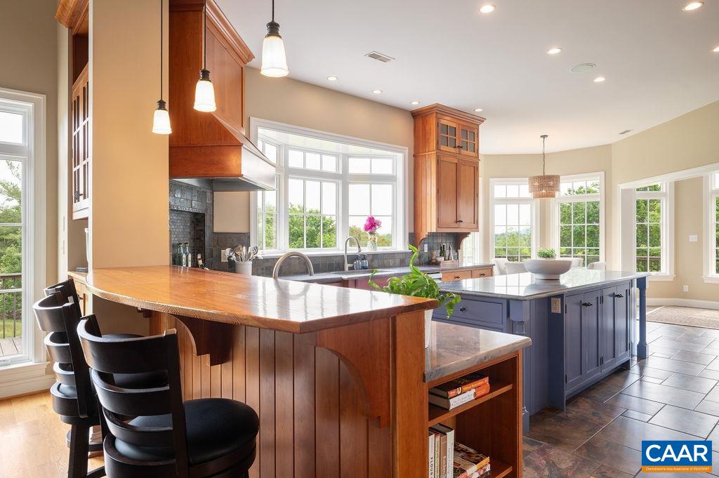 513 Half Mile Branch Road Crozet, VA 22932 - Photo 11 of 57 a kitchen with large windows and wooden cabinets