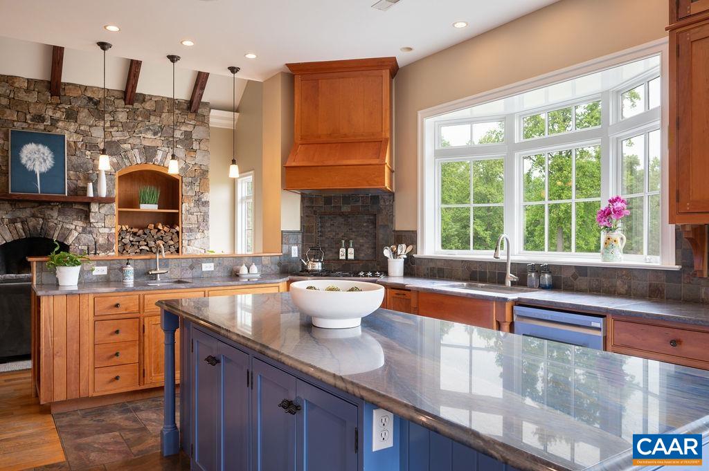 513 Half Mile Branch Road Crozet, VA 22932 - Photo 12 of 57 a kitchen with large windows and wooden cabinets