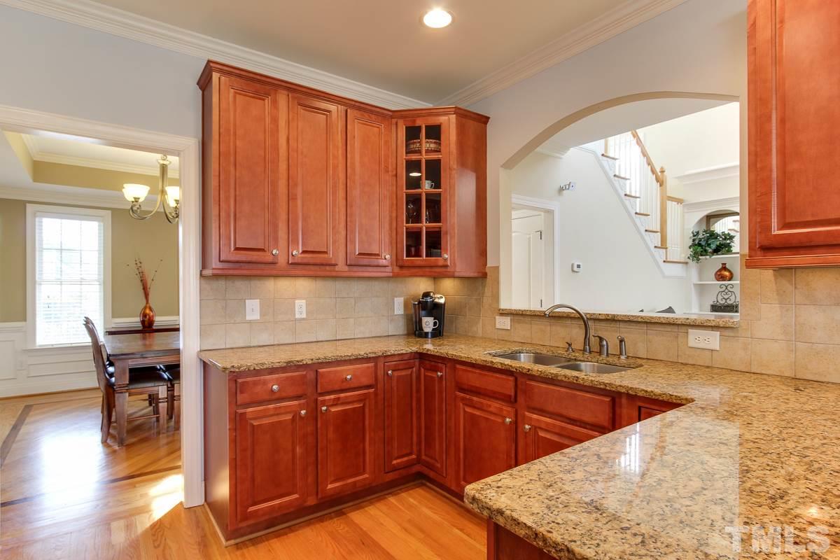 4740 Swordfish Drive Raleigh, NC 27603 - Photo 8 of 25 a kitchen with stainless steel appliances granite countertop wooden cabinets a sink and dishwasher