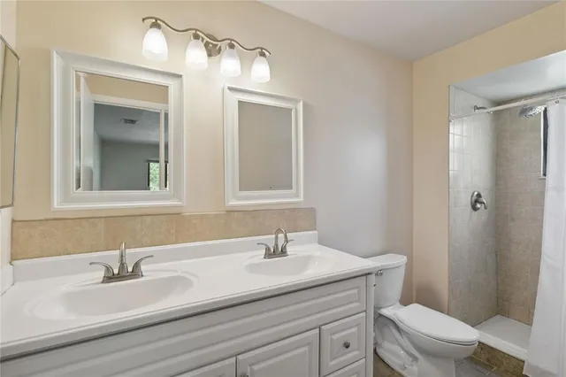 a view of an empty room with a chandelier fan