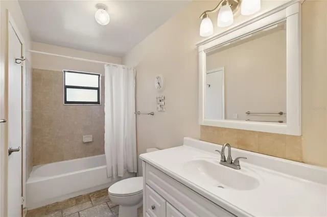 a view of a park with swings and a large tree