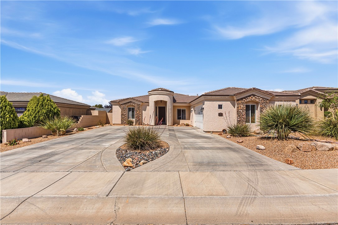 3315 Rainbow Mine Road Kingman, AZ 86401 - Photo 52 of 54 The property features an extensive concrete driveway, a tiled roof, and a stucco exterior with stone accents