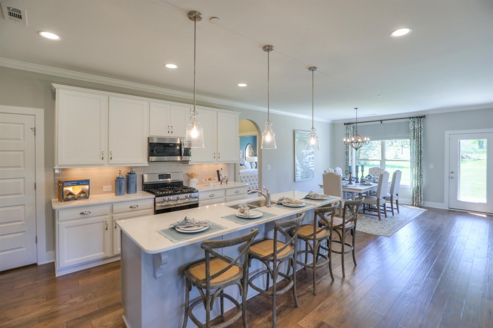 376 Cloverbrook Way Gallatin, TN 37066 - Photo 2 of 24 a kitchen with stainless steel appliances kitchen island granite countertop a stove a sink a dining table and chairs with wooden floor