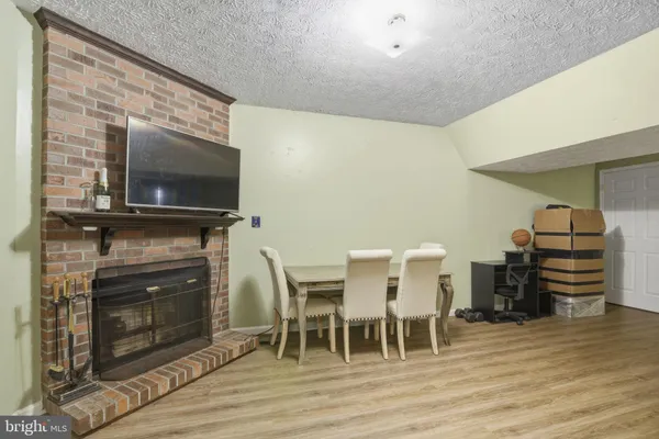 a dining room with furniture a fireplace and wooden floor
