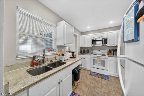 a kitchen with white cabinets a sink and a stove