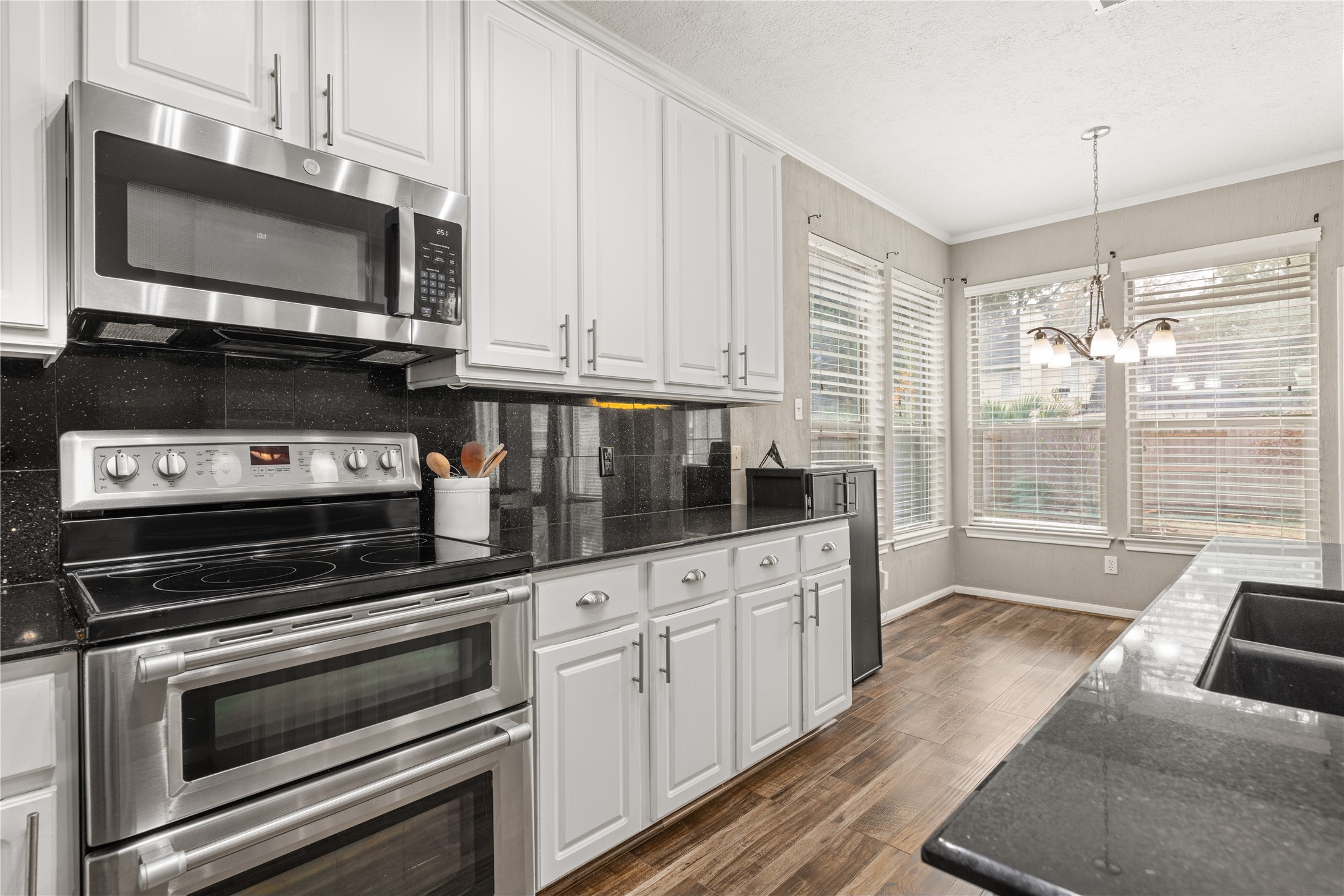 20823 Water Point Trail Humble, TX 77346 - Photo 15 of 43 a kitchen with granite countertop a sink stove and microwave