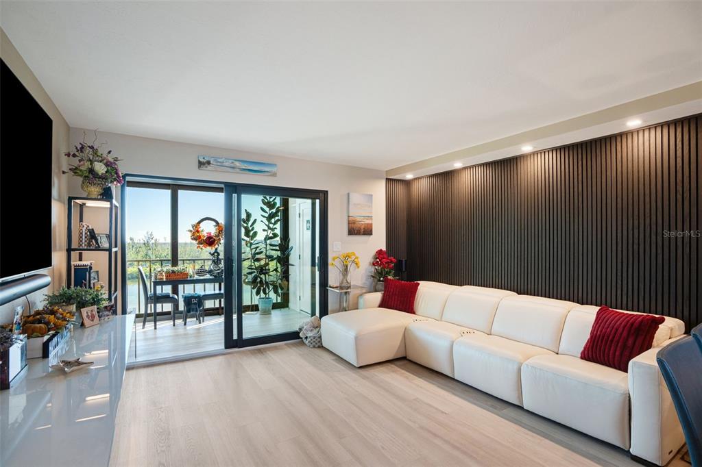 9397 Midnight Pass Road, Unit 905 Sarasota, FL 34242 - Photo 4 of 37 a living room with furniture and a flat screen tv